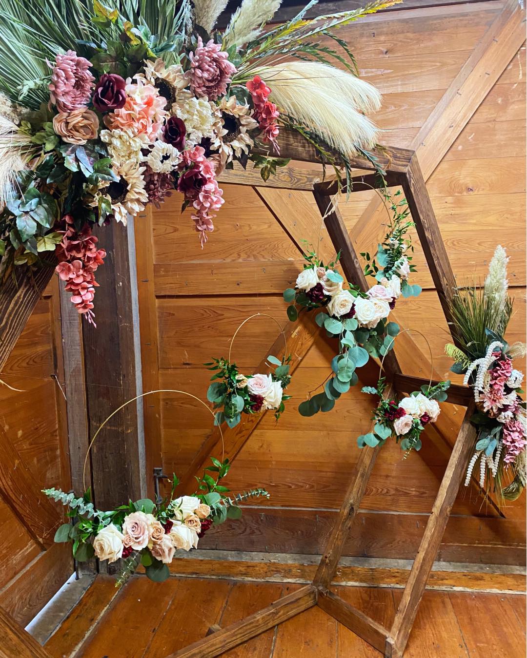 wooden hexagon wedding arch with boho flower arrangements