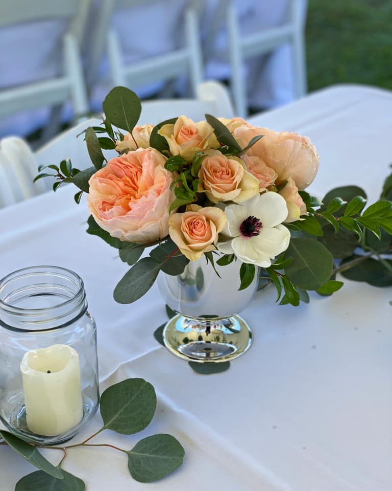 small floral centerpiece with peach roses and peonies