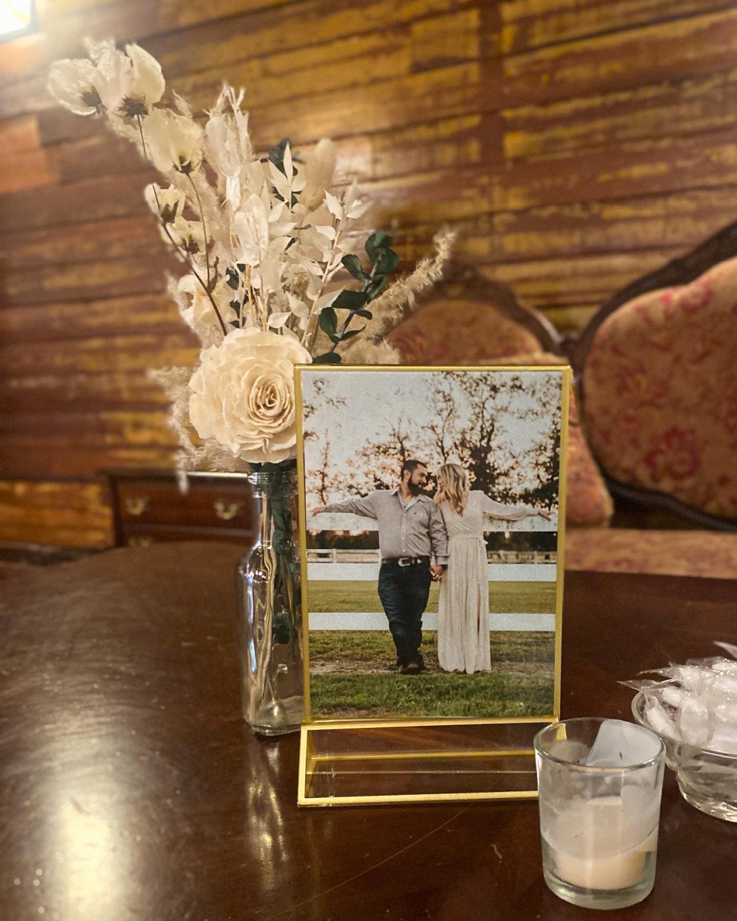 small white floral arrangement with engagement photo of bride and groom