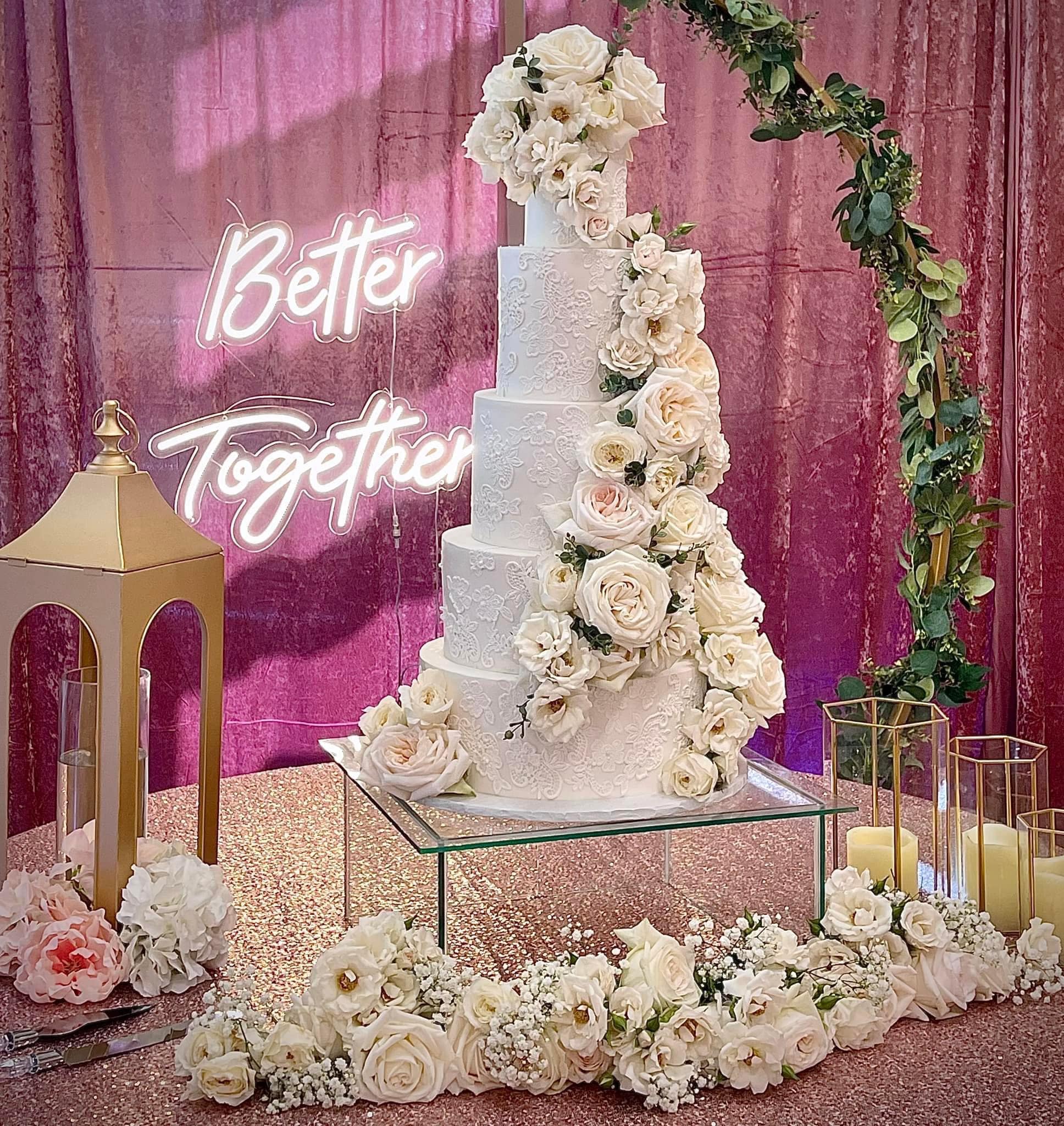 wedding cake with lace pipes and cascading roses